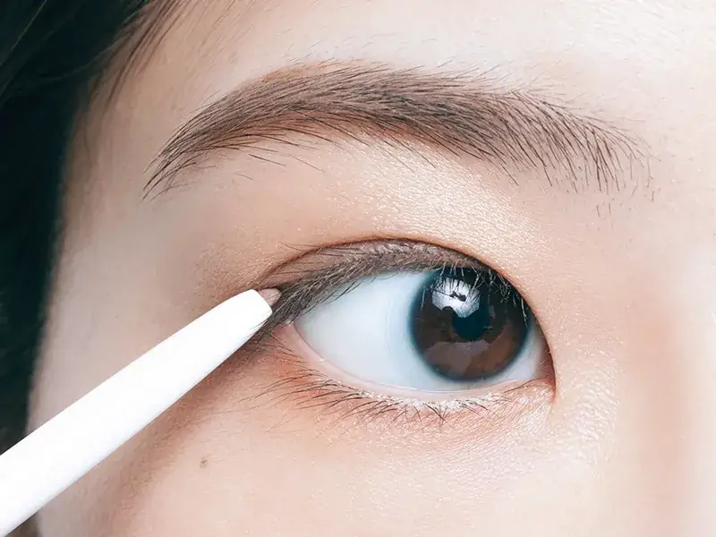 ペンシルアイライナーでまつ毛のきわを描いている工程写真