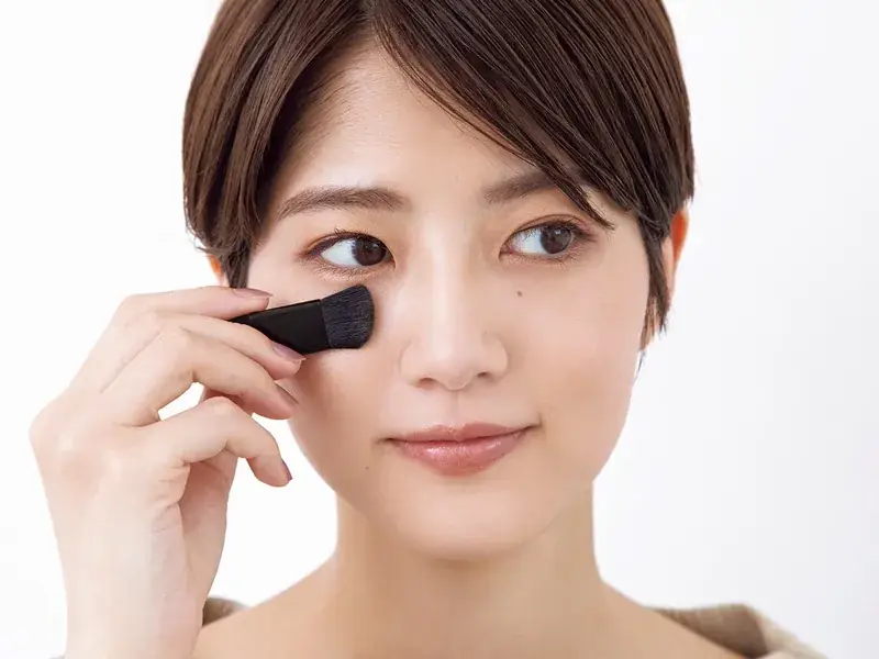 若月佑美さん ブラシでフェイスカラーを頬にのせる様子