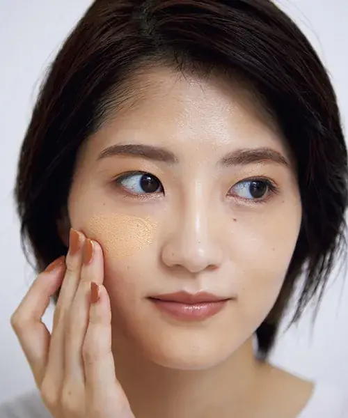 ファンデーションを頬に伸ばしている写真